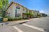 Charming yellow townhouse for rent with lush landscaping on a sunny corner lot, featuring 3 beds and 2.5 baths.