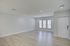 Spacious living area with elegant hardwood flooring and abundant natural light streaming through large windows.