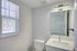 Bright and modern bathroom with sleek fixtures, a large window, and ample natural light.