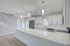 Bright and modern kitchen with sleek white cabinetry, sparkling countertops, and elegant pendant lighting, perfect for culinary adventures.