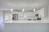 Modern kitchen design with sleek white cabinetry, stainless steel appliances, and elegant pendant lighting.