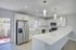 Sleek modern kitchen with stainless steel appliances, elegant white cabinetry, and chic pendant lighting.