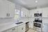 Modern kitchen with sleek white cabinets, stainless steel appliances, and a bright, airy atmosphere.