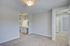 Bright and inviting bedroom with plush carpeting, modern ceiling fan, and sleek bathroom vanity, perfect for luxury living.
