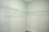 Spacious walk-in closet with sleek wire shelving and a soft carpeted floor offering ample storage space.