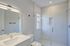 Elegant bathroom with a sleek glass shower, modern vanity, and bright natural lighting.