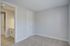 Bright and airy unfurnished room with plush new carpeting and freshly painted walls, connected to a sleek bathroom with modern fixtures.