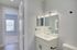 Modern bathroom with sleek vanity and bright window view, offering refreshing natural light and elegant fixtures.