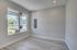 Bright and airy room with large windows and modern grey flooring, perfect for customizable living or office space.