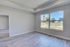 Bright and spacious room with modern flooring and large window offering serene views of lush greenery.