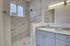 Elegant bathroom with marble accents, featuring a modern walk-in shower, granite countertop, and spacious vanity.