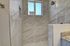 Elegant bathroom with luxurious marble tile walls and modern shower area.