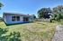 Charming suburban home with large windows and a spacious backyard, perfect for family gatherings and outdoor activities.