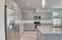 Modern kitchen with sleek stainless steel appliances, elegant gray cabinetry, granite countertops, and a spacious island.