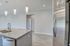 Modern kitchen with sleek granite countertops, stainless steel appliances, and elegant pendant lighting, ideal for contemporary living.