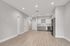 Chic apartment interior showcasing a modern kitchen with stainless steel appliances, elegant cabinetry, and sleek lighting, accentuated by beautiful wood flooring.