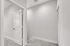 Bright and modern apartment hallway featuring plush carpet and crisp white door, exuding a fresh and welcoming vibe.