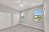 Bright and spacious bedroom featuring plush carpeting, ample closet space, and large windows offering scenic views.