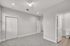 Bright, modern bedroom featuring plush carpeting, sleek ceiling fan, and en-suite bathroom access.