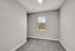 Bright and cozy room with plush carpeting and a sunlit window overlooking greenery, perfect for a home office or guest bedroom.