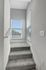 Bright staircase with modern carpeting and large windows letting in ample natural light.