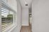 Bright hallway with stylish hardwood floors and large window blinds offering natural light.