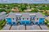 Modern townhouses with vibrant blue accents and spacious driveways in a lush neighborhood.