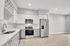 Modern kitchen with sleek stainless steel appliances, elegant white cabinetry, and pristine countertops, perfect for culinary enthusiasts.