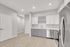 Modern kitchen with sleek appliances, light wood flooring, and elegant cabinetry offering ample storage space.