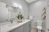 Modern bathroom featuring dual sinks, elegant gray cabinetry, and contemporary decor accents for a spa-like experience.