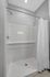 Sleek modern shower featuring elegant white subway tiles and a pristine white shower curtain.