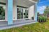Charming apartment patio with modern blue accents, lush greenery, and large sliding glass doors leading inside.