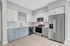 Modern kitchen with sleek stainless steel appliances, elegant white and gray cabinetry, and stylish light wood flooring, perfect for culinary creativity.