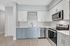 Modern kitchen with sleek cabinetry, stainless steel appliances, and elegant light wood flooring.