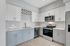 Modern kitchen with sleek white cabinetry, stainless steel appliances, and elegant light-toned flooring.