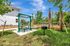 Inviting outdoor space featuring a covered picnic area, lush greenery, and palm trees, perfect for relaxation and gatherings.