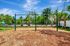 Inviting playground with swings nestled among lush greenery, perfect for family fun and relaxation.