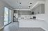 Modern kitchen with sleek gray cabinets, stainless steel appliances, and elegant pendant lighting highlighting a spacious quartz countertop island.