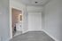 Modern minimalist bedroom featuring elegant hardwood floors, ample closet space, and an en-suite bathroom with contemporary finishes.