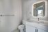 Chic modern bathroom featuring a sleek vanity with an LED mirror, stylish chrome fixtures, and elegant marble flooring.