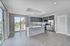 Sleek modern kitchen with stainless steel appliances, island, and large windows for natural light.