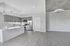 Modern open-concept kitchen with sleek grey cabinetry and stainless steel appliances, complemented by stylish pendant lighting and expansive living space.