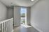 Bright and airy hallway with a large window overlooking a peaceful neighborhood, featuring modern light grey flooring and freshly painted walls.
