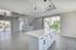 Modern open-concept living space featuring sleek overhead lighting, expansive windows, and a stylish kitchen island, perfect for entertaining.