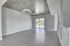 Sleek modern apartment with open floor plan, featuring polished wood floors, a trendy concrete ceiling, and abundant natural light from large sliding glass doors.