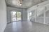 Bright, modern living room with sleek laminate flooring, expansive window views, and stylish staircase leading to the upper level.