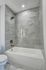 Elegant bathroom with luxurious marble tiles, a modern bathtub, and sleek fixtures creating a spa-like ambiance.