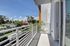 Inviting balcony with sleek railings and scenic views of lush greenery and charming neighborhood.