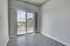 Bright modern room with large sliding glass doors to a balcony, offering a serene outdoor view, perfect for relaxation and natural light.