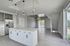 Modern open-concept kitchen and living area featuring sleek cabinetry, elegant lighting, and large windows for natural light.